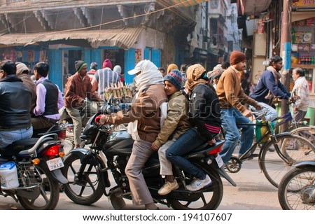 VARANASI, INDIA - JAN 4: Unidentified children and them father on the motorcycle ride on the crowed city with of cycles on January 4, 2013. Varanasi urban agglomeration had a population of 1,435,113