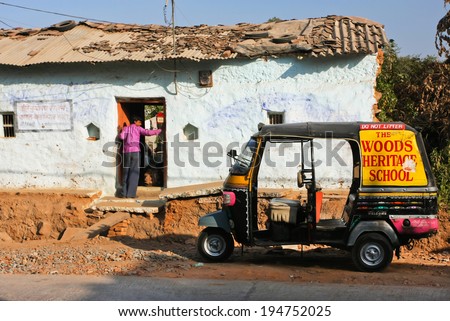 MADHYA PRADESH, INDIA - DEC 22: Driver of auto-rickshaw three-weeler taxi came to old village house on December 22, 2012 in Orchha. Madhya Pradesh is the second largest indian state by area