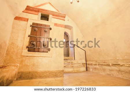 Dungeon on an old synagogue with wrought old shutters and door