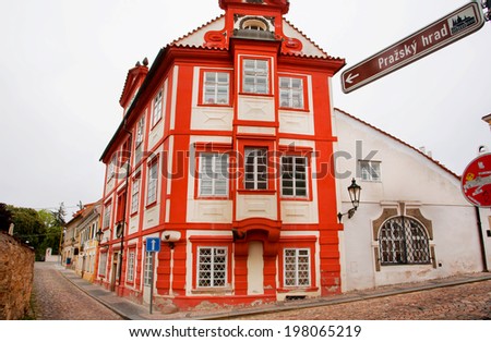 PRAGUE - MAY 16: Red house inside the historical Hradcany district with cobbled streets and old houses on May 16, 2014 in Czech Republic. Prague receives more than 4.4 million visitors annually