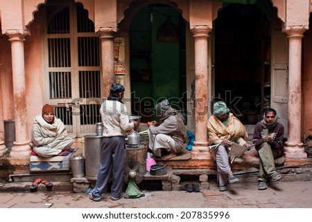 VARANASI, INDIA - JAN 4: Indian men read newspapers and discuss the news on the street early in the morning on January 2, 2013. Varanasi urban agglomeration had a population of 1,435,113