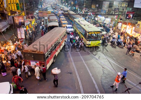 CALCUTTA, INDIA - JAN 18: People run across the street with powerfull traffic road with cycles, cars and buses on January 18, 2013 in India. Kolkata has a density of 814.80 vehicles per km road length
