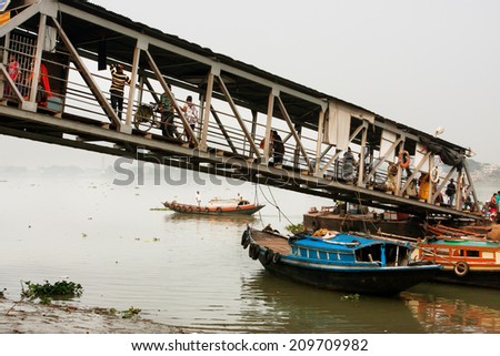 KOLKATA, INDIA - JAN 15: People walk through the river dock from the small ferry on January 15 2013. Third biggest indian city, Kolkata with its suburbs, is home to approximately 14.1 million people