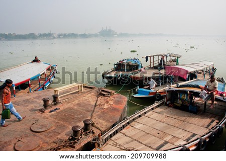 KOLKATA, INDIA - JAN 15: Boat drivers wait for the passengers at the old river dock on January 15, 2013. Third biggest indian city Kolkata with its suburbs is home to approximately 14.1 million people