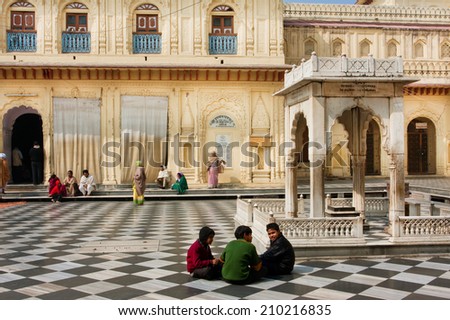 AYODHYA, INDIA - JAN 28: Unidentified children sit on the black and white floor of historic hindu temple Kanak Bhavan on January 28 2013 in Uttar Pradesh. This Lord Rama temple was constructed in 1891