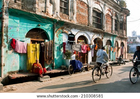 AYODHYA, INDIA - JAN 29: Bicyclists rushing on the narrow street with historical homes in old city on January 29, 2013 in Uttar Pradesh. Ayodhya with popul. of 49,593 is birthplace of Lord Rama