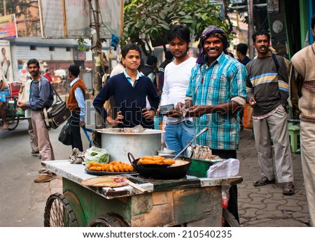 KOLKATA, INDIA - JAN 15: Street trader sells fast food for hungry people on the busy street on January 15 2013. Third biggest indian city Kolkata with suburbs is home to approximately 14 mill.people