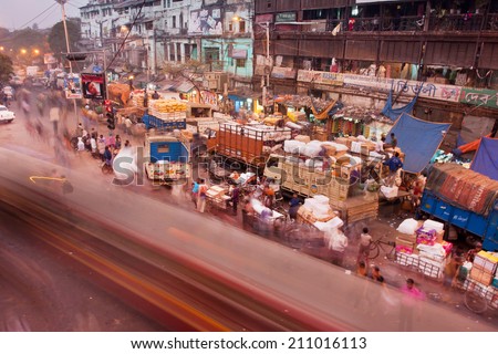 KOLKATA, INDIA - JAN 23: Motion blur of moving buses and lot of city cars and people on market street on January 23, 2013 in Calcutta. Kolkata has a density of 814.80 vehicles per km road length