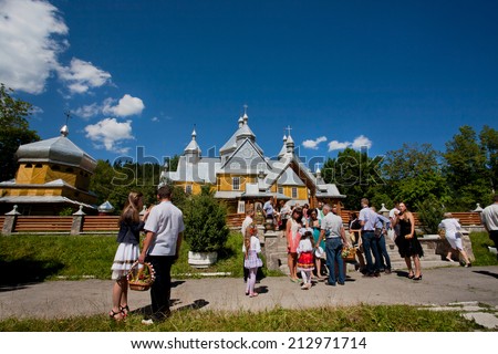 VERKHOVYNA, UKRAINE - AUG 15: People in formal attire go out of the village Orthodox church on August 15, 2014. Verkhovyna with pop. 5,500  is located in the Hutsul region of the Carpathian Mountains
