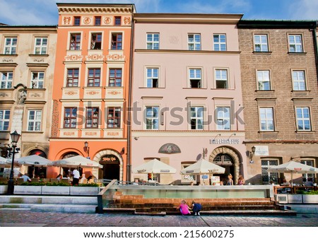 KRAKOW, POLAND - AUG 6: Outdoor cafe & restaurants works near the colorful historical buildings at sunny dayon Aug 6 2014. Krakow with popul. of 800,000 people has 2.35 mill. foreign tourists annually