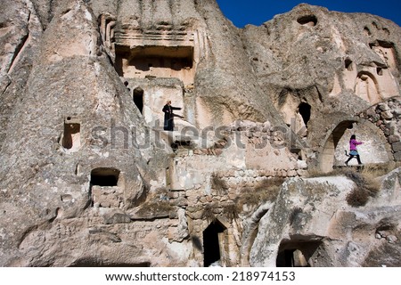 CAPPADOCIA, TURKEY - JAN 4: Mountain home of village people and women walk around the caves on Jan 4, 2012. The first populations of Cappadocia were Hatties, Luvies and Hittites near the 3000 B.C.