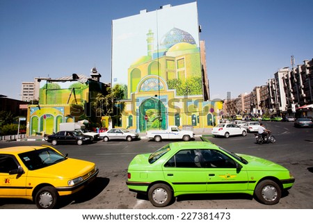 TEHRAN, IRAN - OCTOBER 6: Traffic on sunny road with colorful taxi cars and street art on the building wall  on October 6 2014. With a populat. of 8.3 million, Tehran is 32nd national capital of Iran