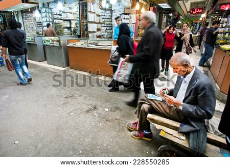 TEHRAN, IRAN - OCTOBER 6: Older serious worker of oriental market earned some money and counts the bills on October 6 2014.
