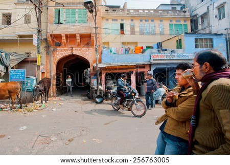 JAIPUR, INDIA - JAN 25: Two men drink traditional tea masala on the dirty indian street on January 25, 2015. Jaipur, with population 6,664000 people, is a capital of Rajasthan
