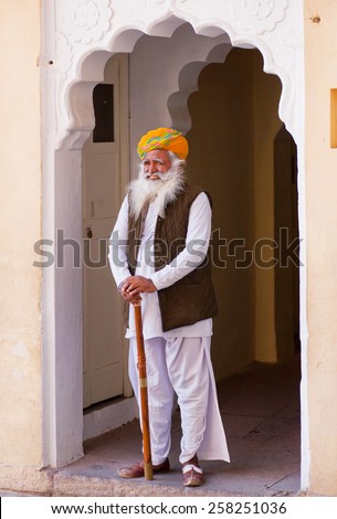 JODHPUR, INDIA - JAN 21: Elderly man in traditional Rajasthan clothes and turban stands in doorway of indian palace on January 21 2015. Jodhpur, with population 1,290,000, is a center of Marwar region