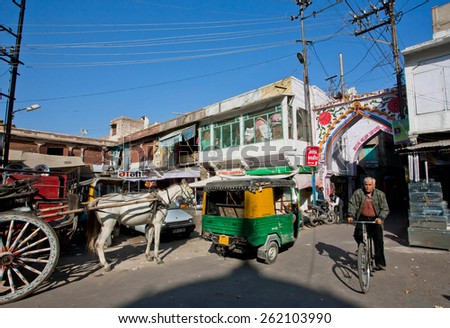 JODHPUR, INDIA - JAN 28: Man driving cycle past retro transport on the indian street on January 28, 2015. Jodhpur, with population 1,290,000 people, is a center of Marwar region of India