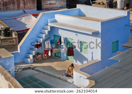 JODHPUR, INDIA - JAN 28: Man resting on the roof of a traditional Indian home, painted in blue color on January 28, 2015. Jodhpur, with population 1,290,000 people, is center of Marwar region of India