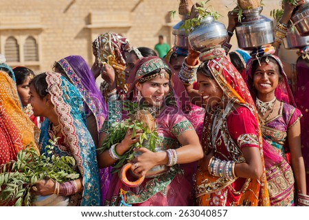 JAISALMER, INDIA - MAR 1: Happy young women dressed in traditional indian sari walking on the famous Desert Festival on March 1, 2015. Every winter Jaisalmer takes the Desert Festival of Rajasthan