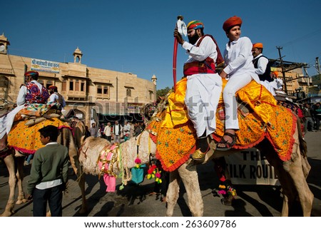 JAISALMER, INDIA - MAR 1: Two brave camel riders with swords going with caravan to the famous Desert Festival on March 1, 2015 in Rajasthan. Every winter Jaisalmer takes the Desert Festival