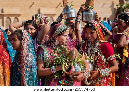 JAISALMER, INDIA - MAR 1: Cute indian girls chatting in the line of colorful women during the famous Desert Festival on March 1, 2015. Every winter Jaisalmer takes the Desert Festival of Rajasthan