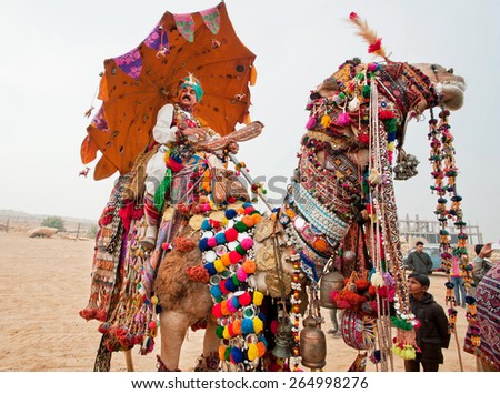 JAISALMER, INDIA - MAR 2: Camel driver riding on the rural show during the famous Desert Festival on March 2, 2015. Every year in the february Jaisalmer takes the village Desert Festival