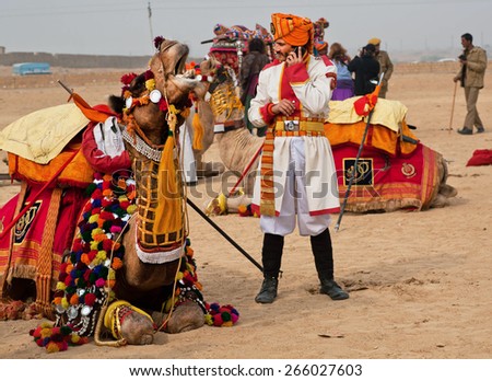JAISALMER, INDIA - MAR 1: Man in old-fashioned military uniform calling by mobile phone near the camel of Desert Festival on March 1 2015 in Rajasthan. Every winter Jaisalmer takes the Desert Festival