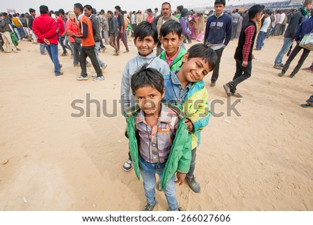 JAISALMER, INDIA - MAR 2: Unidentified happy boys standing one by one in the crowd of people during the famous indian Desert Festival on March 2, 2015. Every winter Jaisalmer takes the Desert Festival