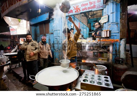 BIKANER, INDIA - MAR 4: Young chef cooks milk with saffron near the street restaurant on March 4, 2015 in Rajasthan. Bikaner has population near 650,000. It was founded by maharajah Rao Bika in 1486