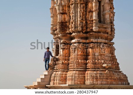 CHITTORGARH, INDIA - FEB 15: Man standing near 12th-century tower Kirti Stambha (Tower of Fame) on February 15, 2015. Chitaurgarh has population about 117,000 and the largest fort in Rajasthan.