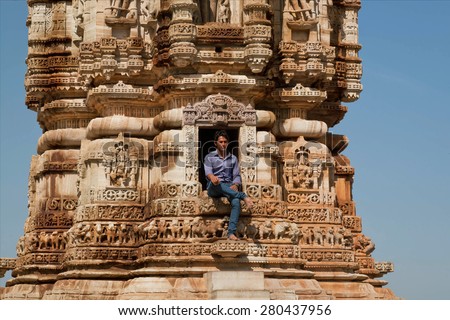 CHITTORGARH, INDIA - FEB 15: Man at front of 12th-century tower Kirti Stambha (Tower of Fame) on February 15, 2015. Chitaurgarh has population about 117,000 and the largest fort in Rajasthan.