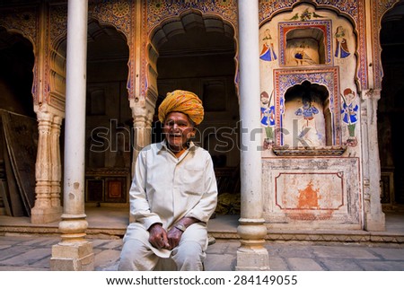 NAWALGARH, INDIA - FEB 6: Elderly man in a turban smiles, sitting inside the old manor on February 6, 2015 in Rajasthan. With population of 100,000, Nawalgarh is education center of Shekhawati region
