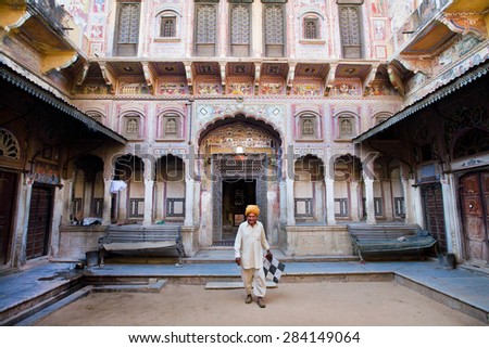 NAWALGARH, INDIA - FEB 6: Old indian man in traditional costume steps from the ancient palace on February 6, 2015 in Rajasthan. With pop. of 100,000, Nawalgarh is education center of Shekhawati region