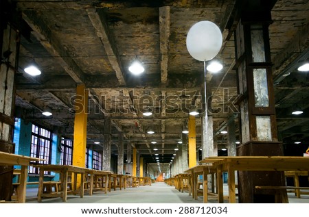 KYIV, UKRAINE - JUNE 8, 2015: White hot air balloon floating in the air of empty factory with old concrete columns inside the building on June 8, 2015. Ukrainian capital, Kiev has popul. near 2,900200