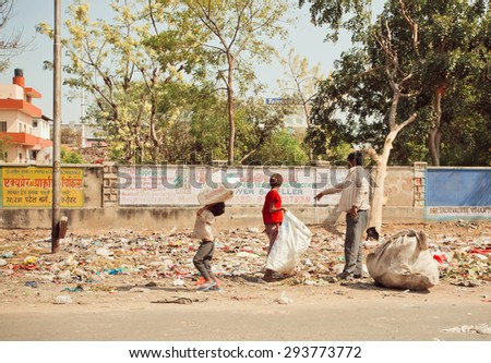 JAIPUR, INDIA - JAN 21: Unidentified children with poor father clean out debris from further recycling process on January 21, 2015. Jaipur, with population 6,664,000 people, is a capital of Rajasthan