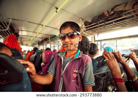 JAIPUR, INDIA - JAN 19: Unidentified boy smiling inside the public bus with many Indian passengers on January 19, 2015. Jaipur, with population 6,664000 people, is a capital of Rajasthan