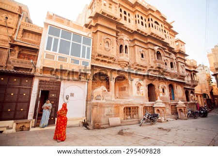 JAISALMER, INDIA - FEB 2: Two housewifes talking in old city area with stone carved  houses on February 2, 2015. Jaisalmer lies in the heart of the Thar Desert and has a population of about 78,000.