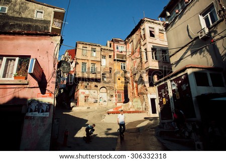 ISTANBUL - JULY 23: People walk near the broken walls of poor street buildings in area Tarlabasi on July 23, 2015 in Turkey. With popul. of 14.4 million, Istanbul is the 5th largest city in world