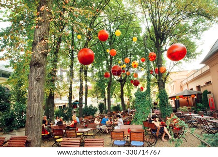 BERLIN, GERMANY - AUG 31: Lounge restaurant with people relaxing under green trees in park on August 31, 2015. Urban area of Berlin comprised 4 million people, 7th most populous in EU