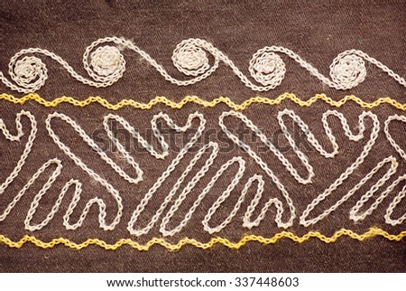 Folk patterns on the tablecloth, sewn in hand-made technique. Fragment of vintage textiles.