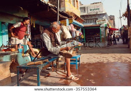 MADHYA PRADESH, INDIA - DEC 29: Senior sitting outdoor and reading an indian newspaper on the street on December 29 2012 in Chitrakoot city. Chitrakoot has an average literacy rate of 50 percent