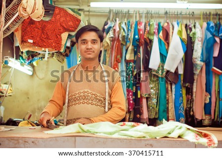 KOLKATA, INDIA - JAN 10: Young tailor sews clothes in a workshop for making dresses on January 10, 2016. Third biggest indian city Kolkata with suburbs is home to approximately 14 mill.people