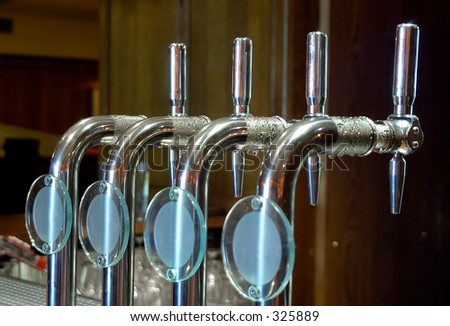 Cold beer taps on a bar, focus on 2nd tap from the left