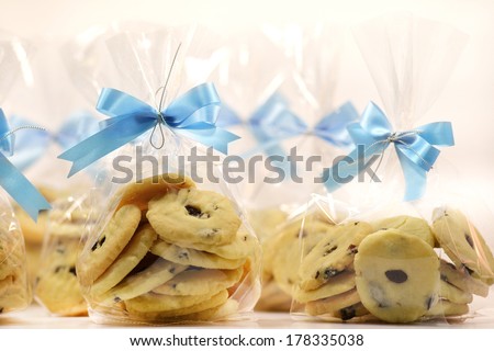 bags of Raisin Cookies with a blue satin ribbon and bow isolated over white background.