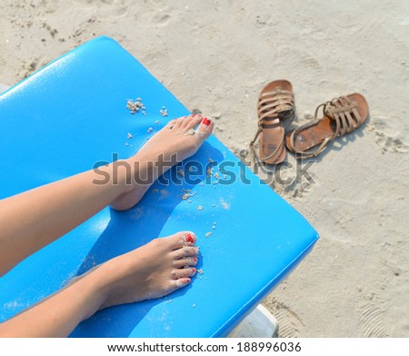 bare feet on deck chair chilling at the beach