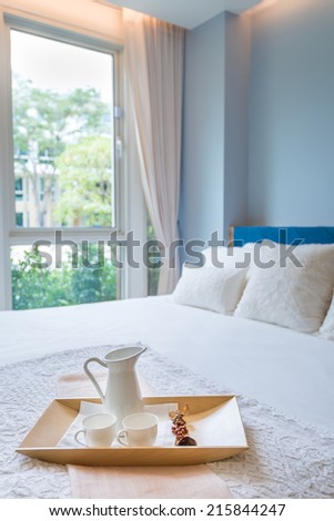 tray of  tea set on bed in bedroom