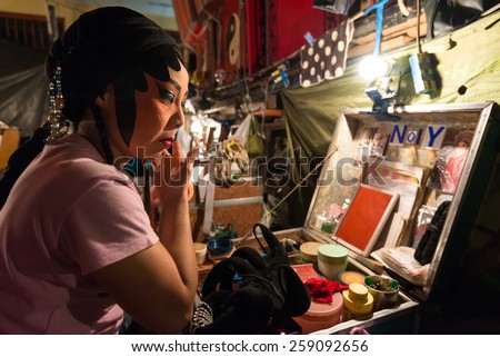 Bangkok, Thailand - January 17th, 2015: A Chinese opera performer dressing in front of a mirror before the show in backstage of a traditional Chinese opera on January 17, 2015 in Bangkok, Thailand.