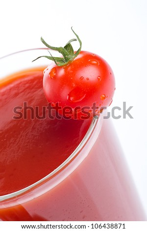 Tomato juice in a glass and cherry tomatoes. Isolated on white background