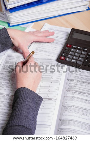 Hands of business woman filling tax form