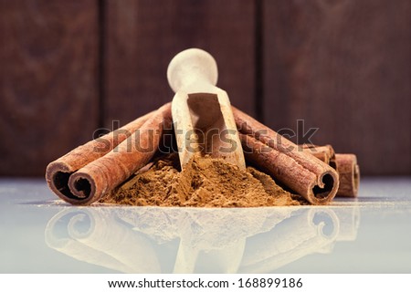 Cinnamon sticks and cinnamon powder on wood floor