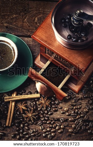 hot cup of coffee and fresh coffee beans and coffee grinder